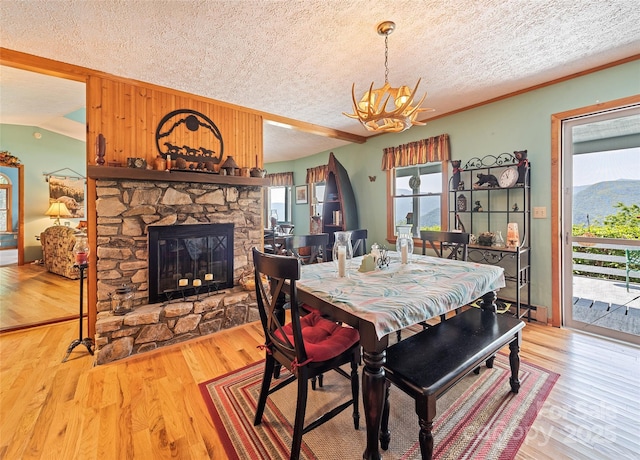724 Pless Underwood Rd, Maggie Valley, NC 28751 - dining space featuring a textured ceiling, a chandelier, wood finished floors, and a stone fireplace
