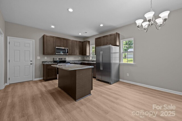 130 Aurora Blvd, Matthews, NC 28105 - kitchen with stainless steel appliances, a kitchen island, light wood finished floors, dark brown cabinetry, and recessed lighting