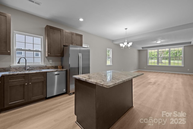 130 Aurora Blvd, Matthews, NC 28105 - kitchen with appliances with stainless steel finishes, light wood-style flooring, open floor plan, dark brown cabinetry, and a chandelier