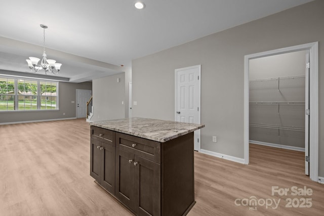 130 Aurora Blvd, Matthews, NC 28105 - kitchen with light wood-style floors, dark brown cabinetry, a chandelier, decorative light fixtures, and open floor plan