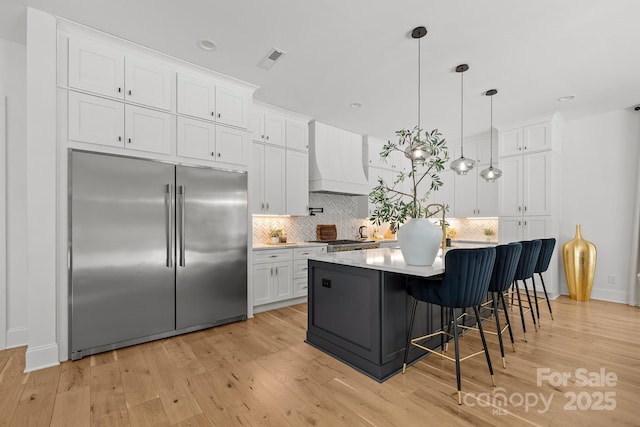 2121 Laburnum Ave, Charlotte, NC 28205 - kitchen featuring stainless steel built in refrigerator, premium range hood, white cabinetry, light wood-style flooring, and recessed lighting