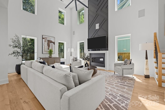 2121 Laburnum Ave, Charlotte, NC 28205 - living area with a high ceiling, light wood-style flooring, a fireplace, and stairway