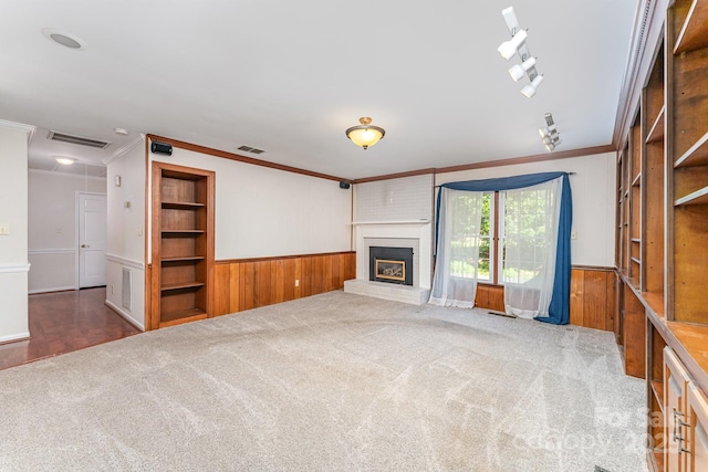 220 Blackberry Trl, Concord, NC 28027 - unfurnished living room with ornamental molding, wainscoting, wooden walls, carpet floors, and a brick fireplace