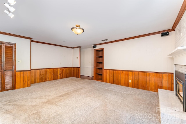220 Blackberry Trl, Concord, NC 28027 - unfurnished living room featuring wainscoting, wood walls, a brick fireplace, carpet, and crown molding