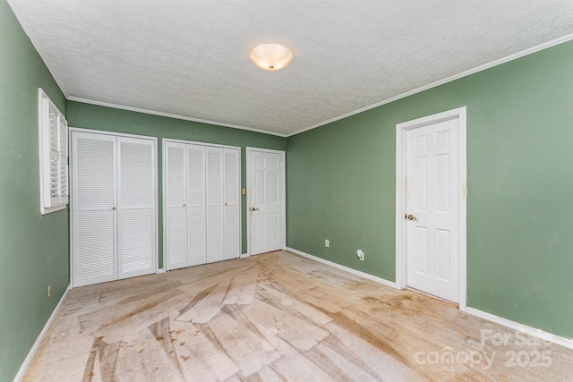220 Blackberry Trl, Concord, NC 28027 - unfurnished bedroom with two closets, a textured ceiling, baseboards, carpet, and ornamental molding