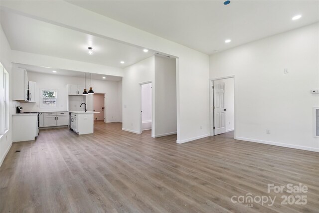 113 Woodside Ave, Gastonia, NC 28054 - unfurnished living room featuring light wood finished floors and recessed lighting