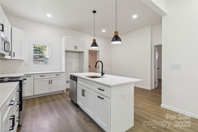 113 Woodside Ave, Gastonia, NC 28054 - kitchen with stainless steel appliances, wood finished floors, white cabinets, a kitchen island with sink, and recessed lighting
