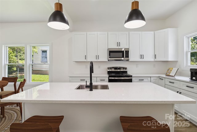 113 Woodside Ave, Gastonia, NC 28054 - kitchen featuring appliances with stainless steel finishes, light stone countertops, and a breakfast bar