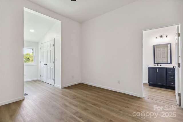 113 Woodside Ave, Gastonia, NC 28054 - unfurnished bedroom featuring wood finished floors, ensuite bath, a closet, and lofted ceiling