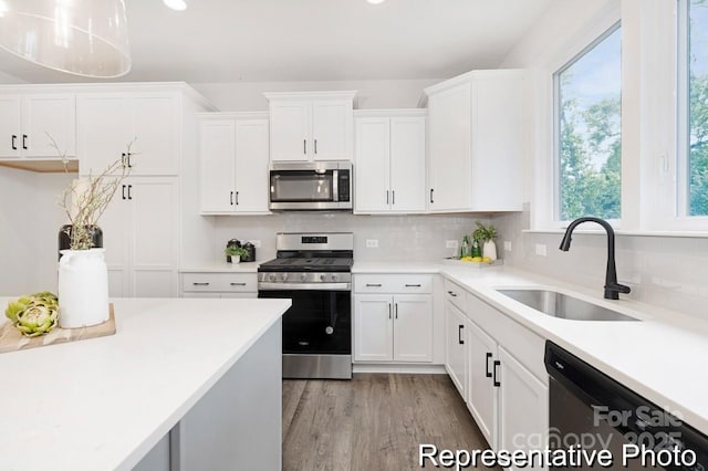 24578 Blue Heron Cir Unit 407, Lancaster, SC 29720 - kitchen with stainless steel appliances, a sink, white cabinets, light countertops, and tasteful backsplash