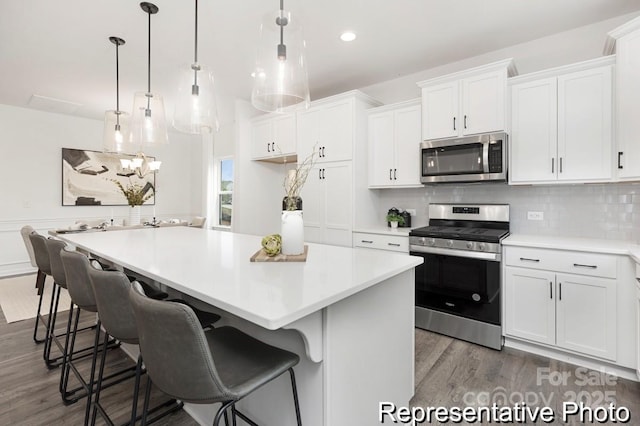 24578 Blue Heron Cir Unit 407, Lancaster, SC 29720 - kitchen featuring stainless steel appliances, wood finished floors, white cabinetry, light countertops, and a kitchen island
