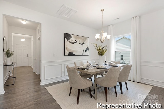 24578 Blue Heron Cir Unit 407, Lancaster, SC 29720 - dining area featuring a chandelier, dark wood-type flooring, a decorative wall, and a wainscoted wall