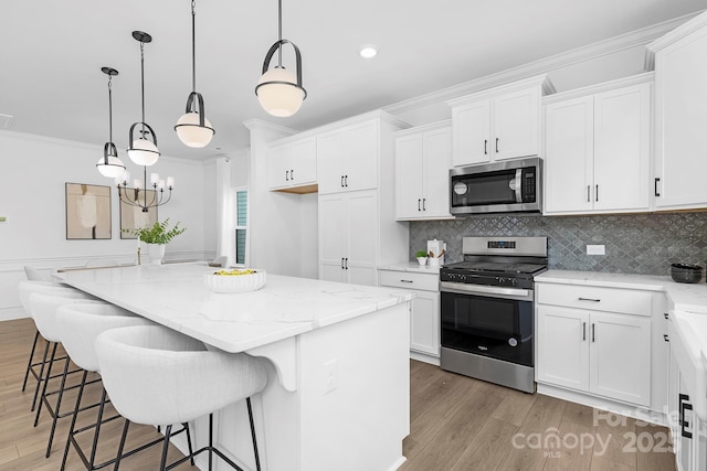 24578 Blue Heron Cir Unit 407, Lancaster, SC 29720 - kitchen featuring appliances with stainless steel finishes, light wood-style flooring, light stone countertops, crown molding, and white cabinets
