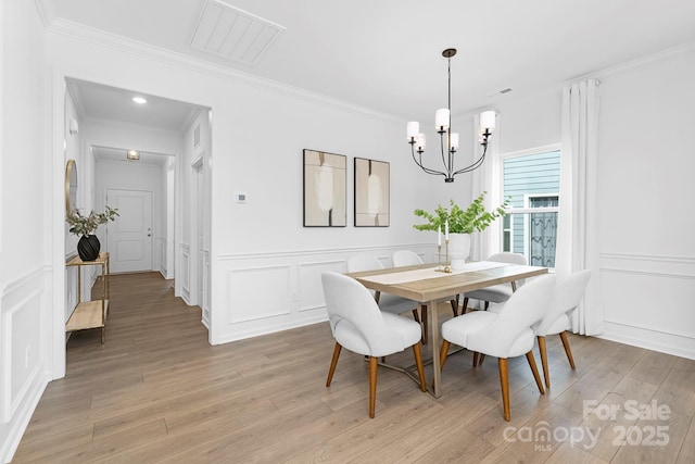 24578 Blue Heron Cir Unit 407, Lancaster, SC 29720 - dining area with a decorative wall, a chandelier, ornamental molding, light wood finished floors, and wainscoting