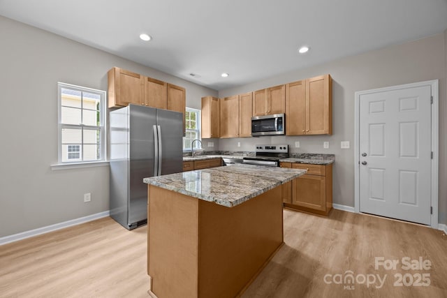 126 Aurora Blvd, Matthews, NC 28105 - kitchen featuring stainless steel appliances, light wood finished floors, light stone counters, a kitchen island, and recessed lighting