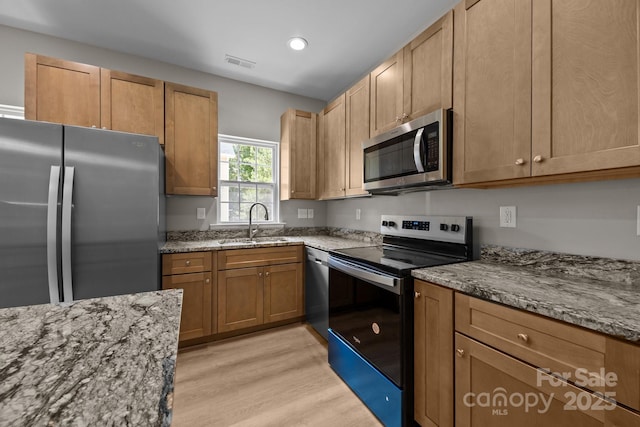 126 Aurora Blvd, Matthews, NC 28105 - kitchen with stainless steel appliances, stone counters, light wood-type flooring, recessed lighting, and brown cabinetry