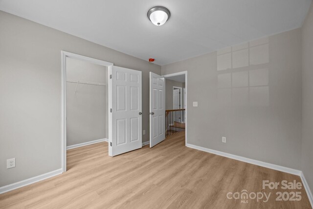 126 Aurora Blvd, Matthews, NC 28105 - unfurnished bedroom featuring wood finished floors, a closet, and a walk in closet