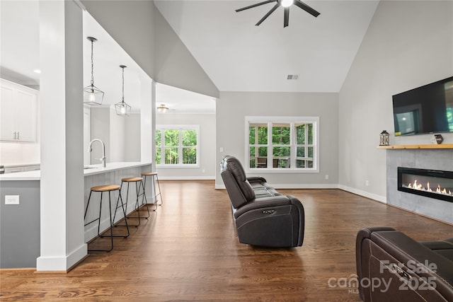 1004 E Sandy Ridge Rd, Monroe, NC 28112 - living area with high vaulted ceiling, a ceiling fan, wood finished floors, and a tiled fireplace
