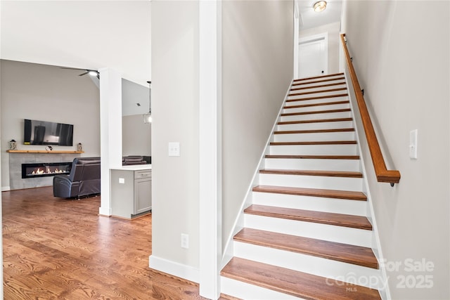 1004 E Sandy Ridge Rd, Monroe, NC 28112 - stairway with a glass covered fireplace and wood finished floors