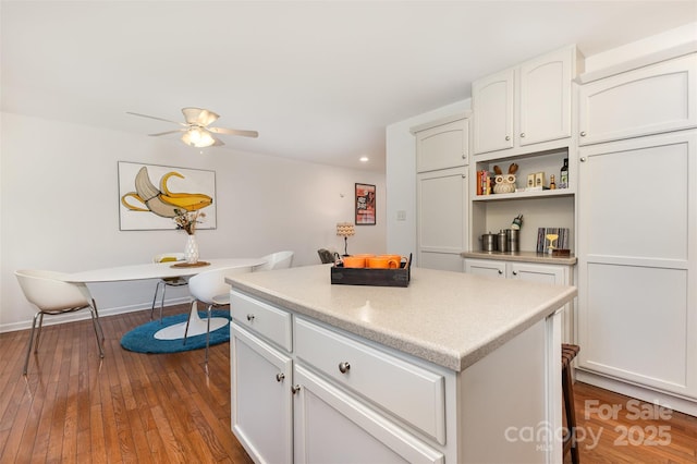1912 Baxter St, Charlotte, NC 28204 - kitchen with a kitchen island, white cabinets, ceiling fan, dark wood-type flooring, and light countertops