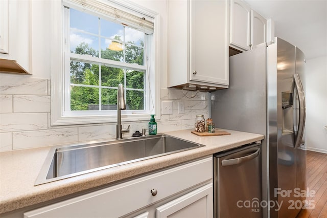 1912 Baxter St, Charlotte, NC 28204 - kitchen with stainless steel dishwasher, decorative backsplash, white cabinetry, and light countertops