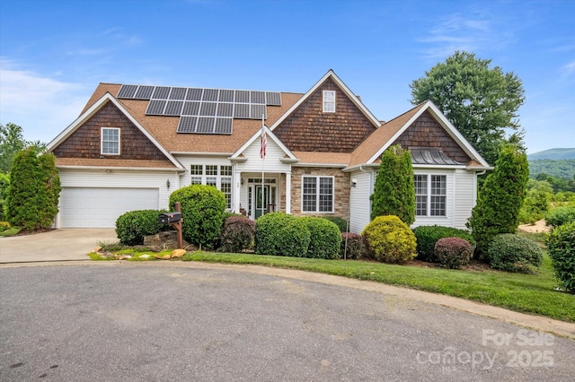 30 Linn Garden Ln, Swannanoa, NC 28778 - view of front of home featuring concrete driveway, solar panels, a shingled roof, a garage, and stone siding