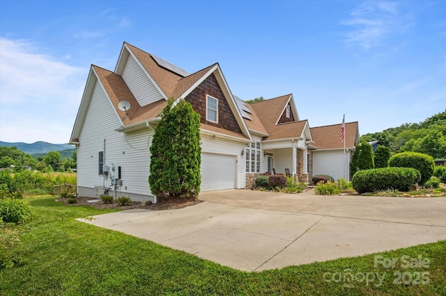 30 Linn Garden Ln, Swannanoa, NC 28778 - view of property exterior with driveway, a lawn, roof mounted solar panels, a shingled roof, and covered porch