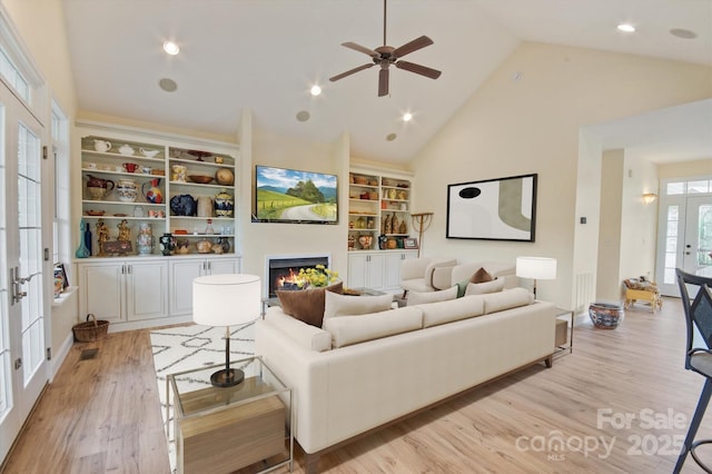 30 Linn Garden Ln, Swannanoa, NC 28778 - living room with light wood finished floors, a warm lit fireplace, a ceiling fan, high vaulted ceiling, and french doors