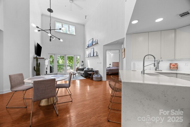 415 N Church St Unit 311, Charlotte, NC 28202 - dining area with wood finished floors, a towering ceiling, a chandelier, and recessed lighting