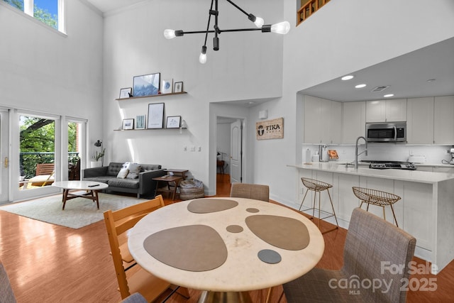 415 N Church St Unit 311, Charlotte, NC 28202 - dining room with a high ceiling, light wood-style floors, healthy amount of natural light, a chandelier, and ornamental molding