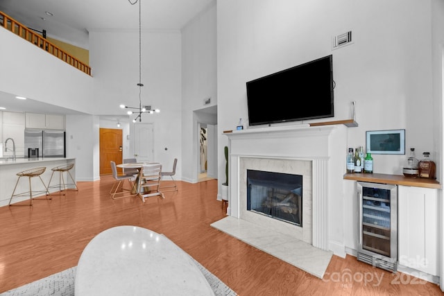 415 N Church St Unit 311, Charlotte, NC 28202 - living area featuring wine cooler, light wood finished floors, a towering ceiling, and a high end fireplace