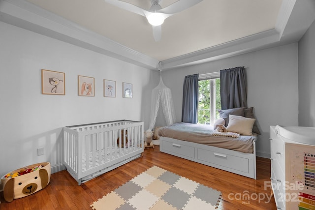 415 N Church St Unit 311, Charlotte, NC 28202 - bedroom with wood finished floors, crown molding, a tray ceiling, and a ceiling fan