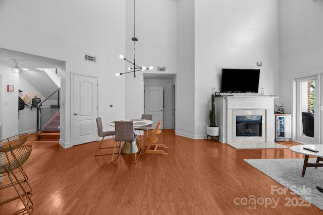 415 N Church St Unit 311, Charlotte, NC 28202 - dining room featuring a high ceiling, wood finished floors, stairway, a fireplace with flush hearth, and wine cooler