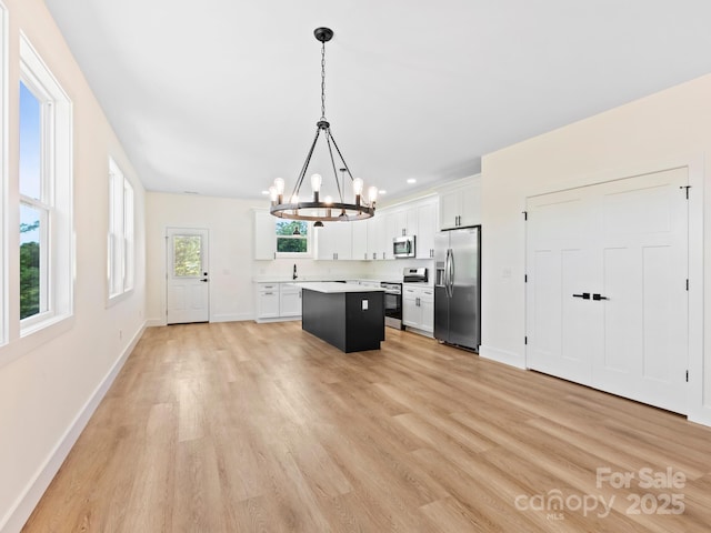 169 Vineyard Village Dr S Unit 4, Old Fort, NC 28762 - kitchen featuring stainless steel appliances, a chandelier, a center island, light countertops, and light wood-type flooring