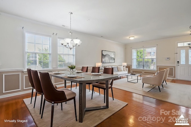 8915 Merrie Rose Ave, Charlotte, NC 28213 - dining area featuring a chandelier, crown molding, a wainscoted wall, and wood finished floors