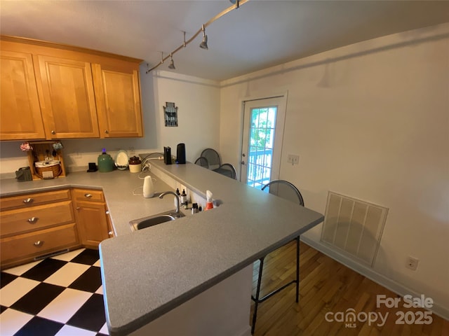 5570 George Henry Dr, Hickory, NC 28602 - kitchen with a peninsula, a breakfast bar, dark floors, track lighting, and light countertops