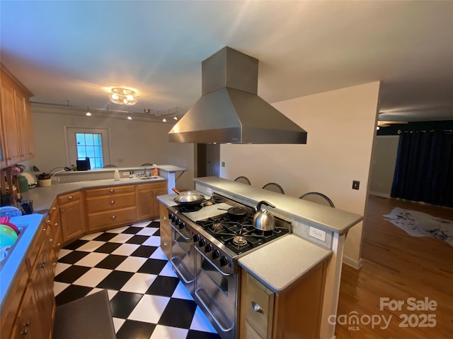 5570 George Henry Dr, Hickory, NC 28602 - kitchen featuring island range hood, range with two ovens, a peninsula, dark flooring, and light countertops