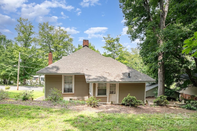 816 Fulton St, Albemarle, NC 28001 - back of property featuring a chimney, a yard, and roof with shingles