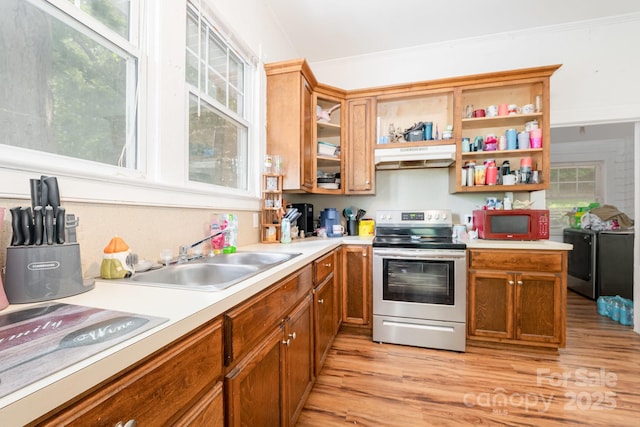 816 Fulton St, Albemarle, NC 28001 - kitchen featuring stainless steel electric range, white microwave, under cabinet range hood, light wood-style flooring, and light countertops
