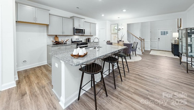 4238 Steel Way, Sherrills Ford, NC 28673 - kitchen with appliances with stainless steel finishes, a sink, a kitchen breakfast bar, an island with sink, and light stone countertops