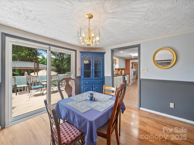 3509 Flint Dr, Statesville, NC 28677 - dining room with a chandelier, ornamental molding, a textured ceiling, and light wood-type flooring