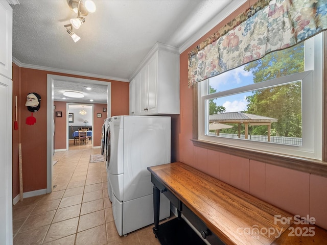 3509 Flint Dr, Statesville, NC 28677 - washroom featuring cabinet space, crown molding, light tile patterned flooring, and washer and clothes dryer
