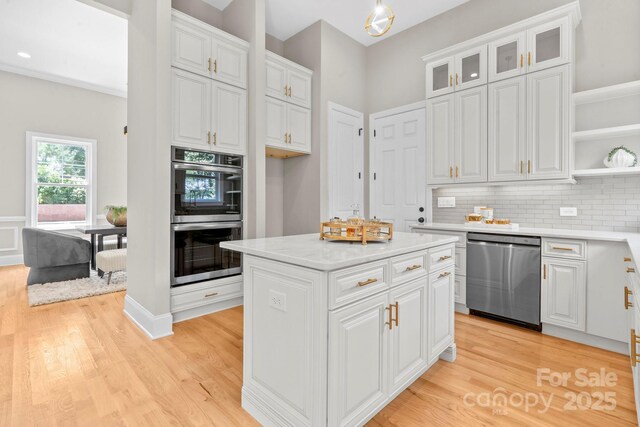 4015 Randolph Rd, Charlotte, NC 28211 - kitchen with appliances with stainless steel finishes, white cabinetry, a kitchen island, and light wood-style floors