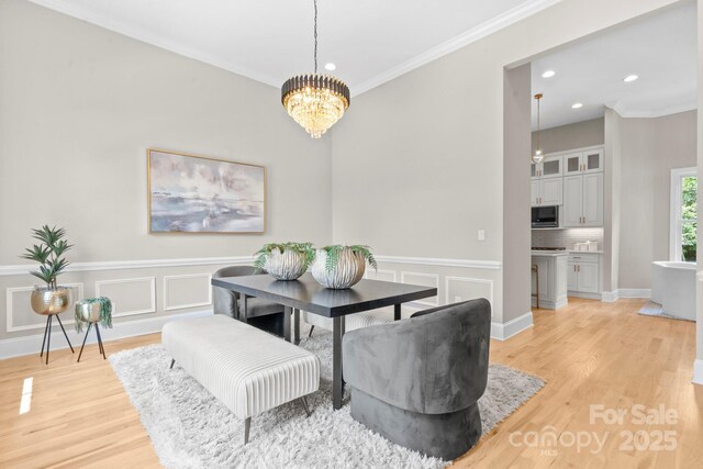 4015 Randolph Rd, Charlotte, NC 28211 - dining space with a chandelier, light wood-style flooring, recessed lighting, ornamental molding, and wainscoting