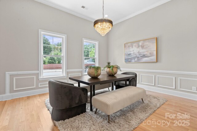 4015 Randolph Rd, Charlotte, NC 28211 - dining space with a chandelier, light wood finished floors, a wainscoted wall, and ornamental molding