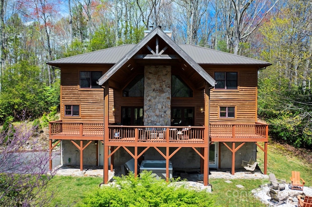 40 Ollis Ridge Ln, Elk Park, NC 28622 - back of house featuring a fire pit, a deck, stone siding, metal roof, and a lawn