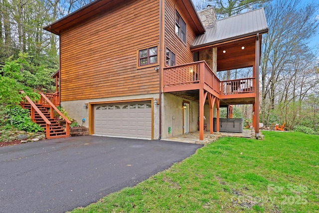 40 Ollis Ridge Ln, Elk Park, NC 28622 - view of home's exterior with a hot tub, a garage, a deck, a yard, and metal roof