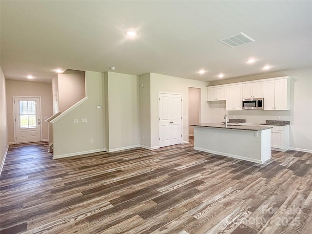 414 1st Ave SE, Hickory, NC 28602 - kitchen featuring stainless steel microwave, dark wood-type flooring, open floor plan, white cabinetry, and baseboards