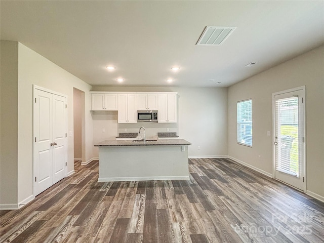 414 1st Ave SE, Hickory, NC 28602 - kitchen with stainless steel microwave, dark wood-style flooring, white cabinets, baseboards, and recessed lighting