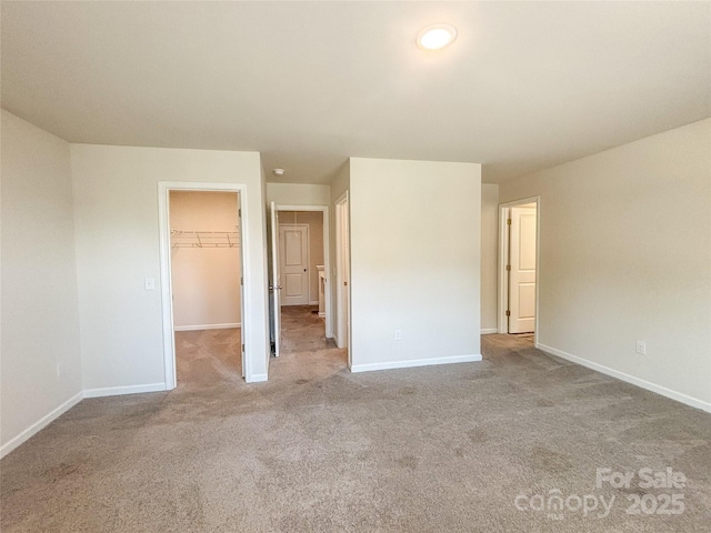 414 1st Ave SE, Hickory, NC 28602 - unfurnished bedroom with carpet, a spacious closet, baseboards, and a closet